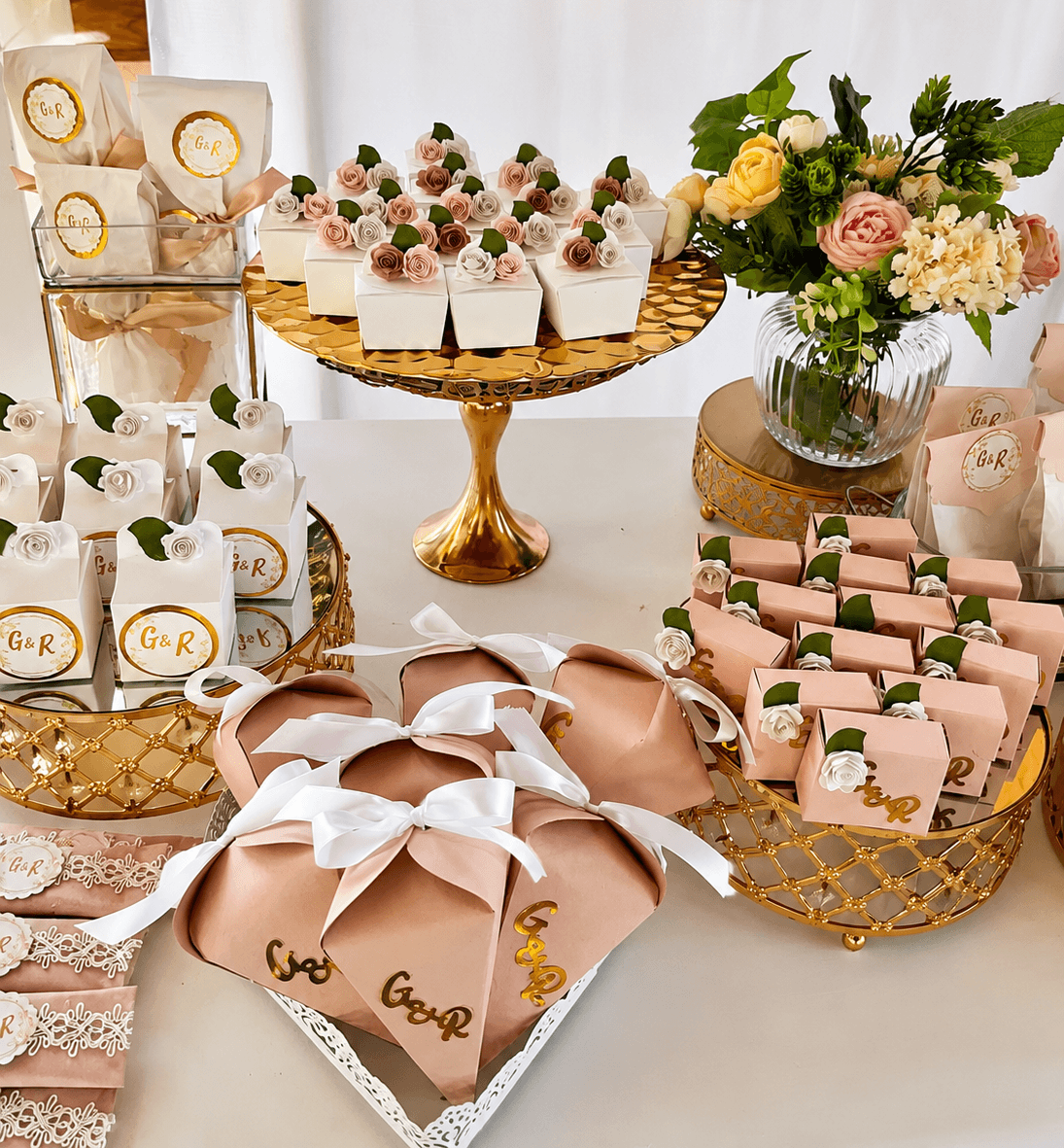 Mesa de recuerdos personalizados para boda con detalles dorados y rosas